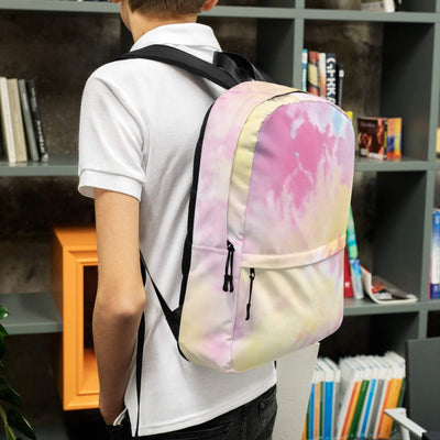 medium size backpack with pastel tie-dye design worn by person indoors