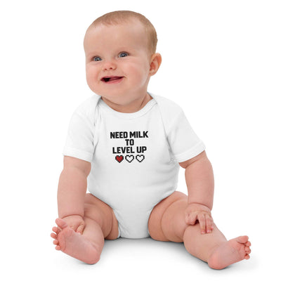 baby wearing paper peace organic cotton white bodysuit with "Need milk to level up" text and pixel heart design