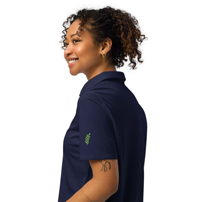 Under Armour women’s polo in navy with breathable, lightweight fabric and anti-odor technology, modeled by a smiling woman