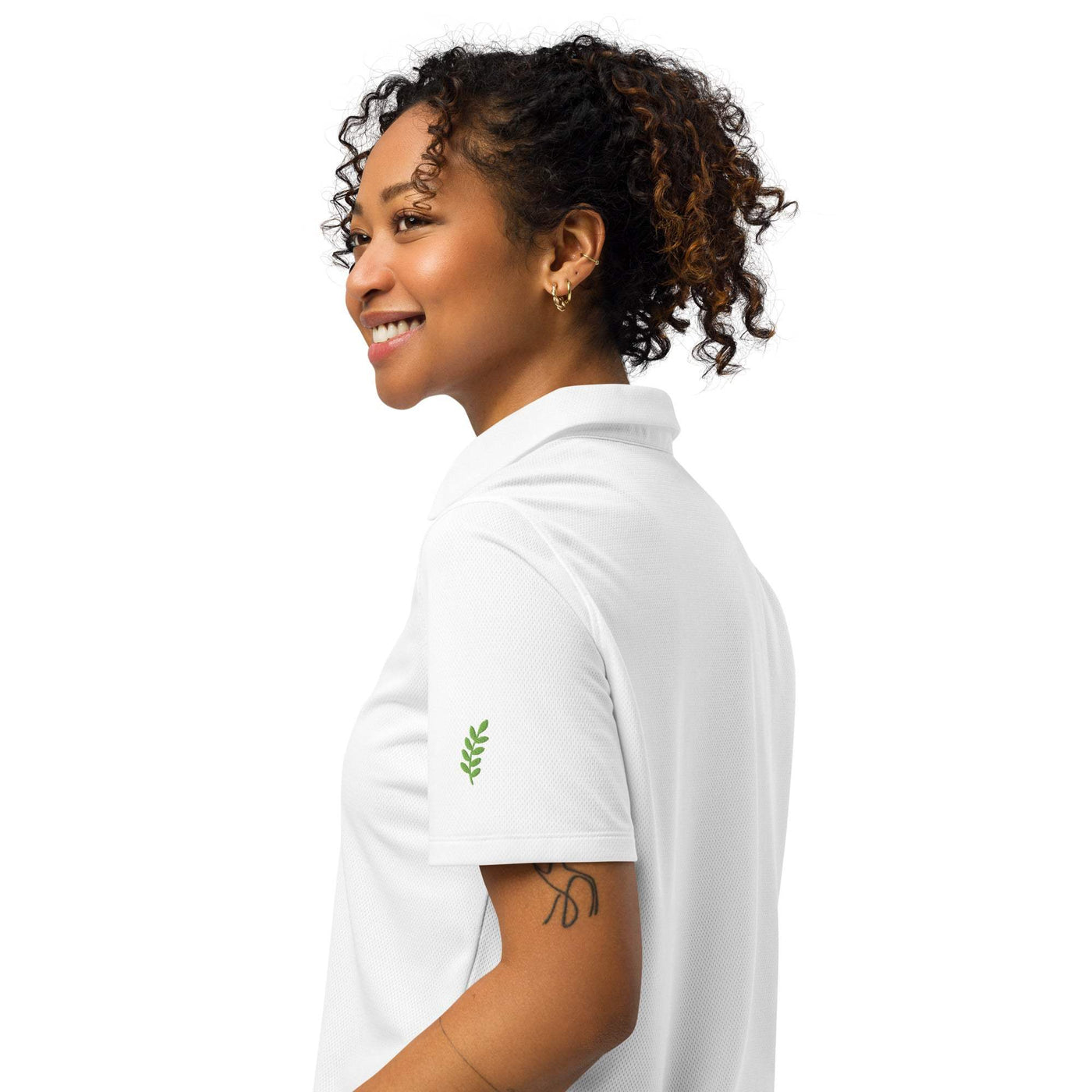 Under Armour women’s polo in white with breathable lightweight fabric and relaxed fit worn by smiling woman from side view